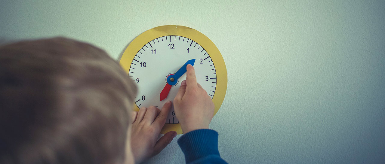 Family time - Boy adjusting time on paper clock